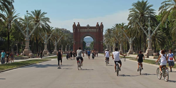 Cyclists cycing towards the Arc de Triomf in Barcelona